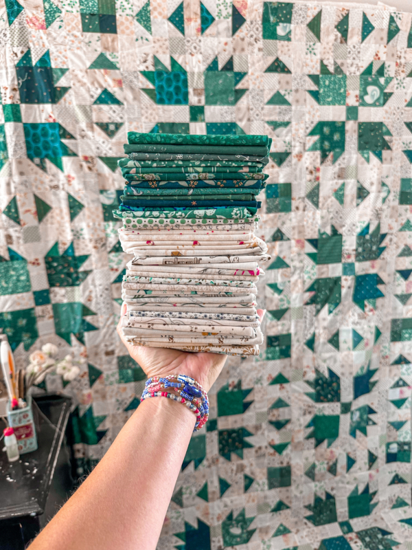 teal and low volume fabric stack in front of bear paw quilt